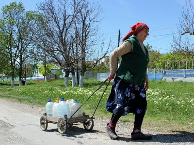 Жительница села Льговка Судакского района Крыма направляется за водой к уличной колонке. Фото: Юрий Лашов / РИА Новости